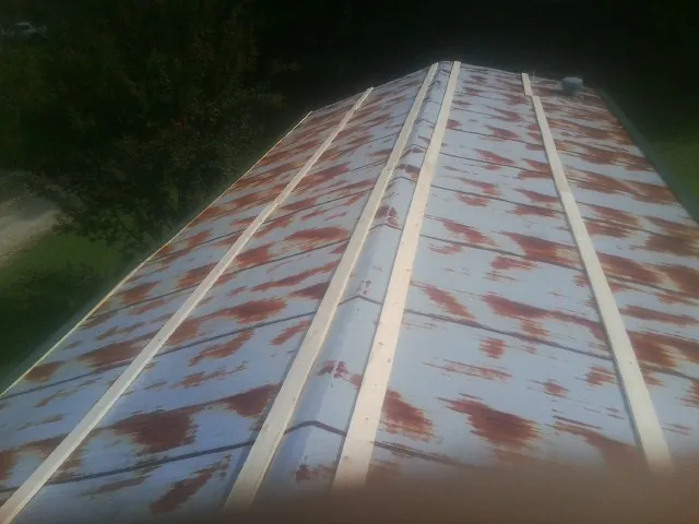 Rusted metal roof panels with new wood purlins before replacement — Storm Damage Roof Repair in Lovejoy by Roofing Brothers