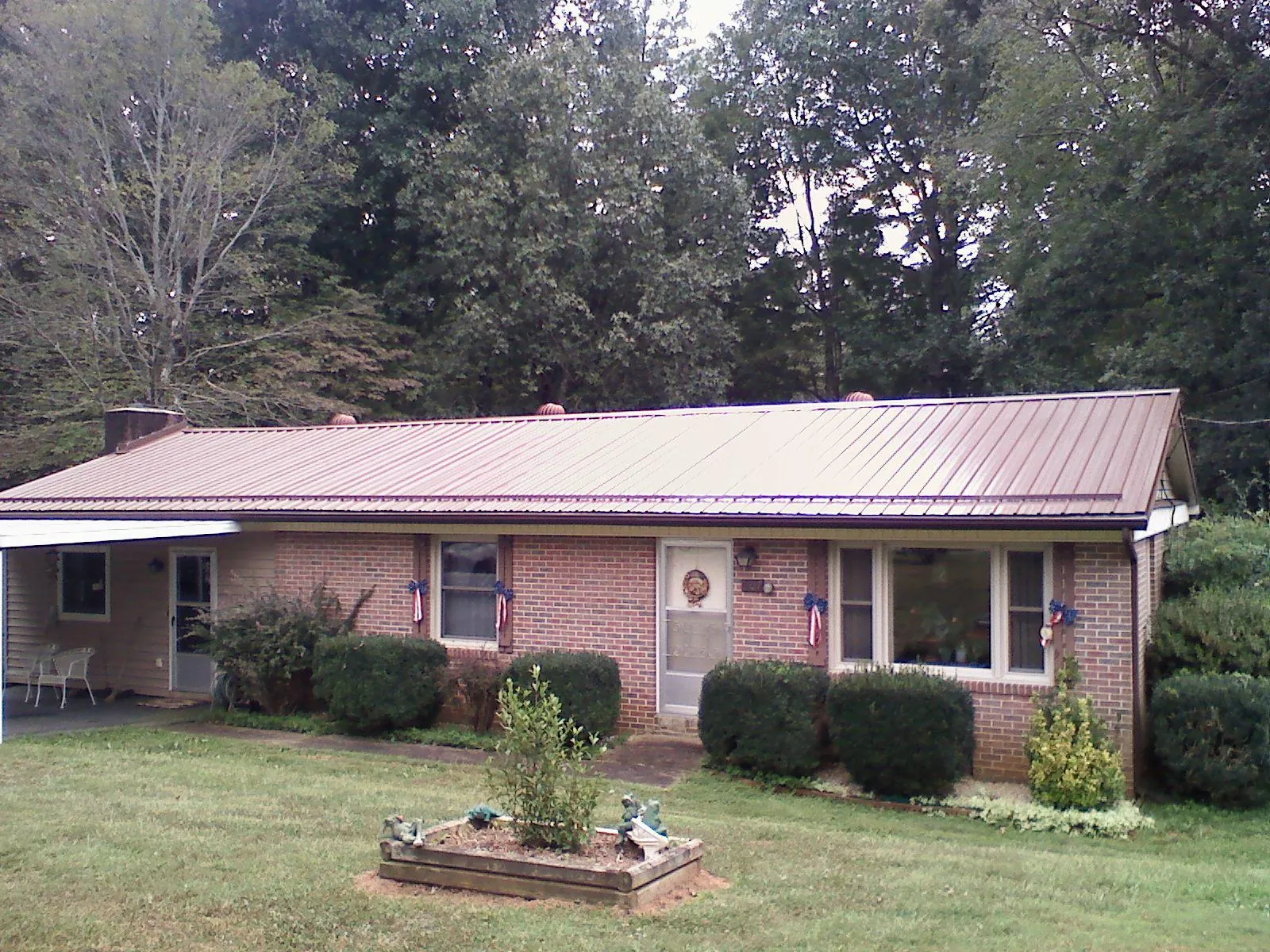 Bronze metal roof on a brick ranch home with a carport in Lovejoy